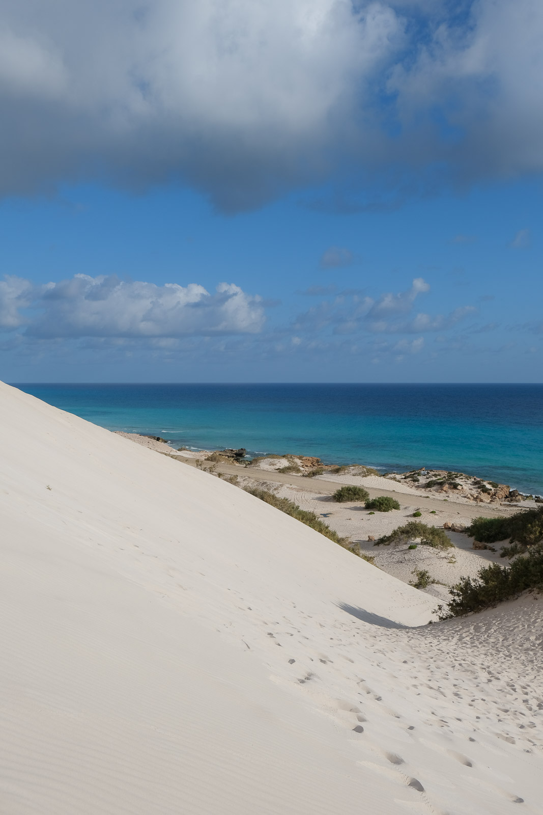 Dune against blue water=